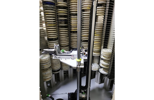 The mechanical gripper grabs the material reel and stores it nearby